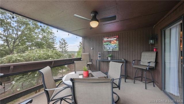 balcony featuring outdoor dining area and a ceiling fan