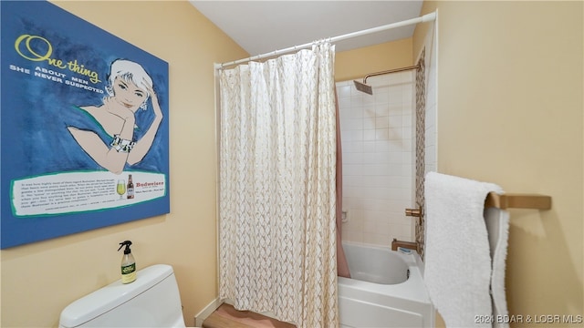 bathroom with shower / bath combination with curtain and toilet