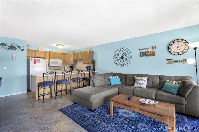 living room with a textured ceiling and light tile patterned flooring