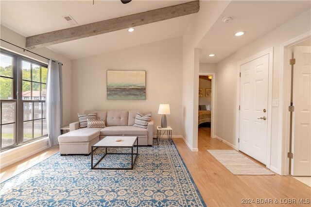 living room with vaulted ceiling with beams and light hardwood / wood-style flooring