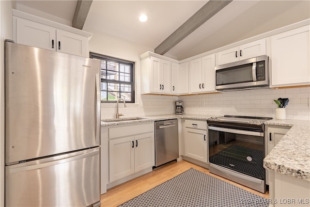 kitchen with sink, decorative backsplash, white cabinets, and stainless steel appliances