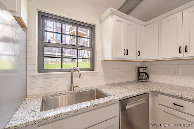 kitchen featuring dishwasher, white cabinets, sink, and light stone counters