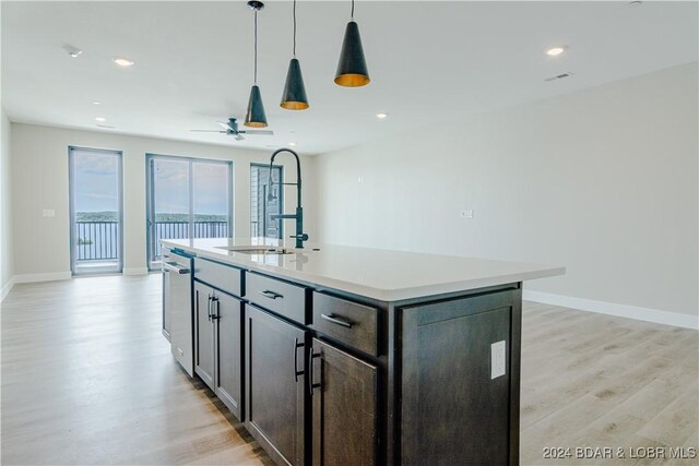 182 Vintage Dr Unit 4A, Lake Ozark, MO 65049 - kitchen featuring a sink, light wood-style floors, baseboards, light countertops, and stainless steel dishwasher