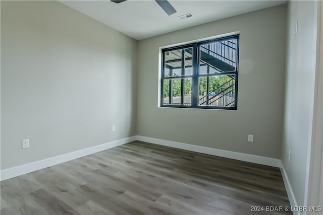 unfurnished room with wood finished floors, visible vents, ceiling fan, and baseboards