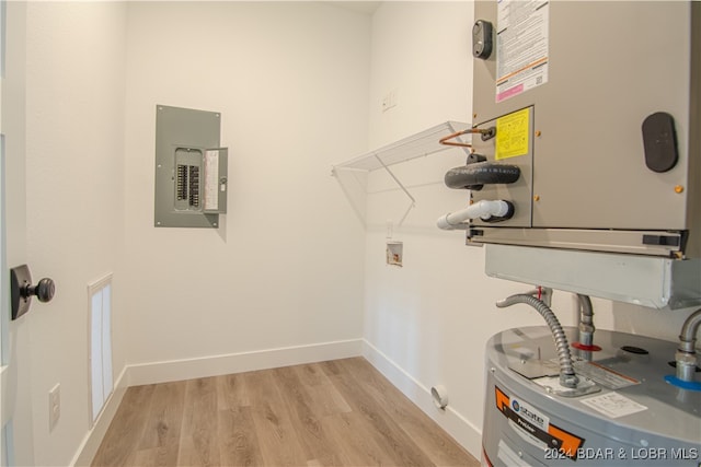 utility room featuring electric panel and water heater