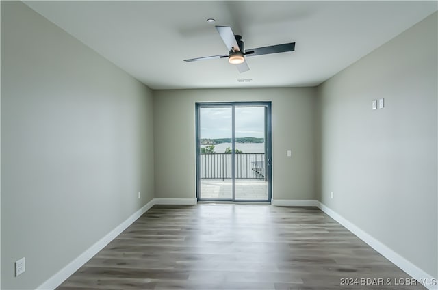 unfurnished room featuring ceiling fan, dark wood-type flooring, visible vents, and baseboards