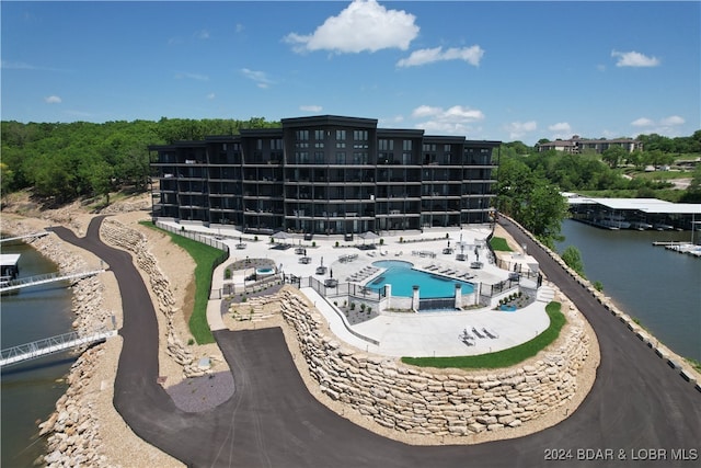 view of swimming pool featuring a patio area and a water view