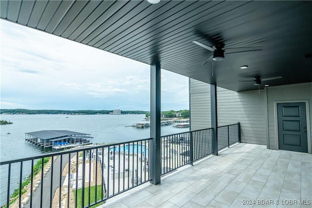 balcony with a water view and a ceiling fan