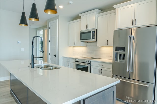 kitchen featuring an island with sink, stainless steel appliances, and white cabinets