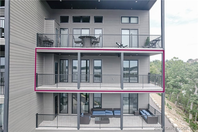 rear view of property featuring outdoor lounge area and a balcony