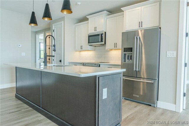 182 Vintage Dr Unit 4A, Lake Ozark, MO 65049 - kitchen with a sink, baseboards, appliances with stainless steel finishes, and light wood-type flooring