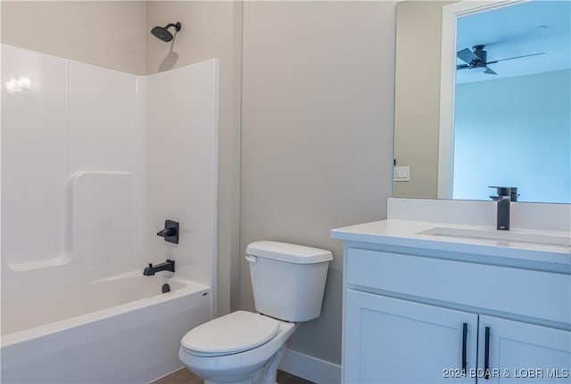 bathroom with vanity, shower / bathtub combination, toilet, a ceiling fan, and baseboards