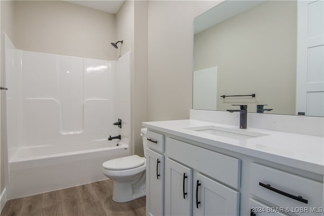 bathroom featuring vanity, shower / washtub combination, wood finished floors, and toilet