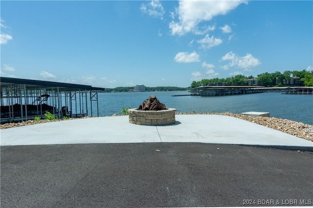 view of patio / terrace featuring an outdoor fire pit and a water view