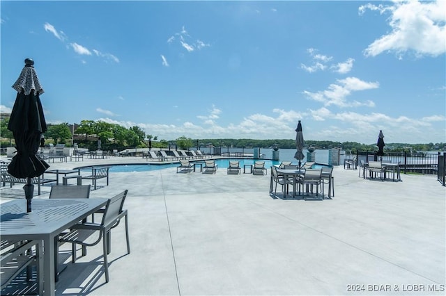 pool featuring fence and a patio area