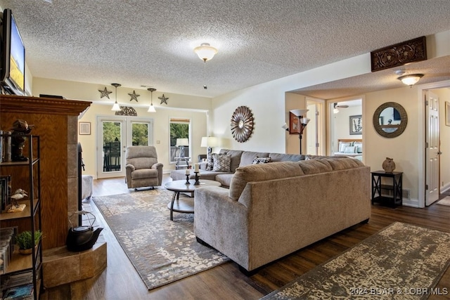 living room with dark hardwood / wood-style flooring, a textured ceiling, and french doors