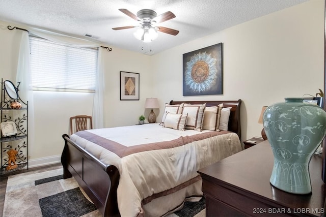 bedroom featuring ceiling fan and a textured ceiling