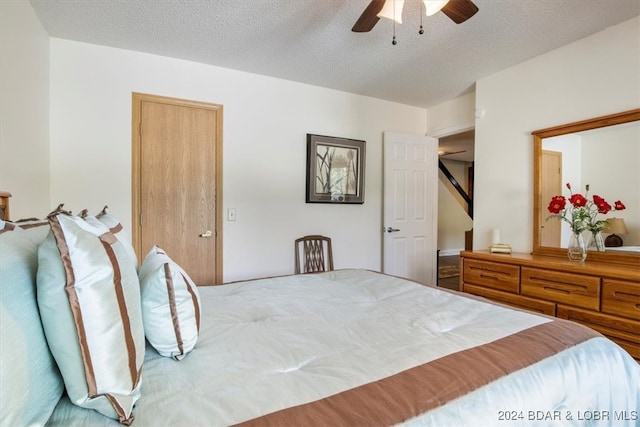 bedroom with ceiling fan and a textured ceiling