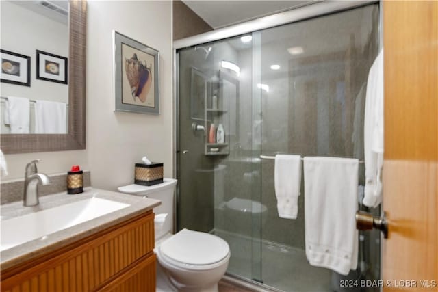 bathroom with toilet, a stall shower, visible vents, and vanity