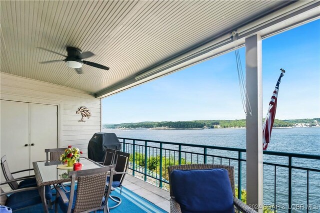 balcony featuring area for grilling, ceiling fan, and a water view