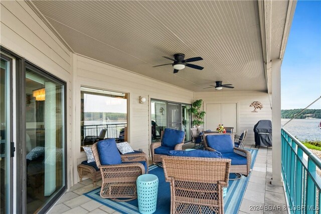 balcony with a water view, ceiling fan, and an outdoor living space