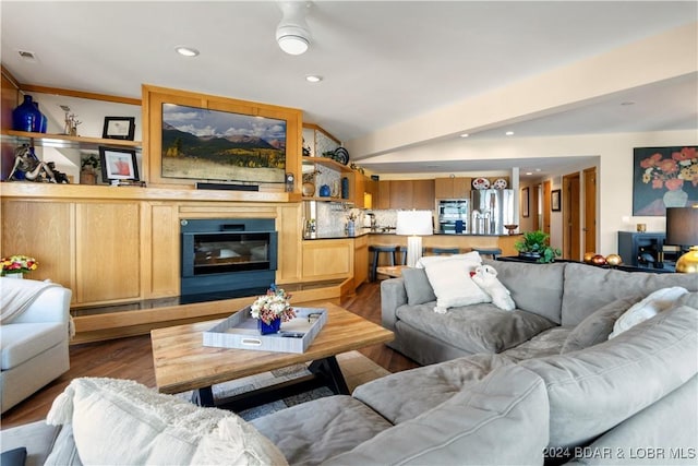 living room featuring visible vents, a glass covered fireplace, lofted ceiling, wood finished floors, and recessed lighting