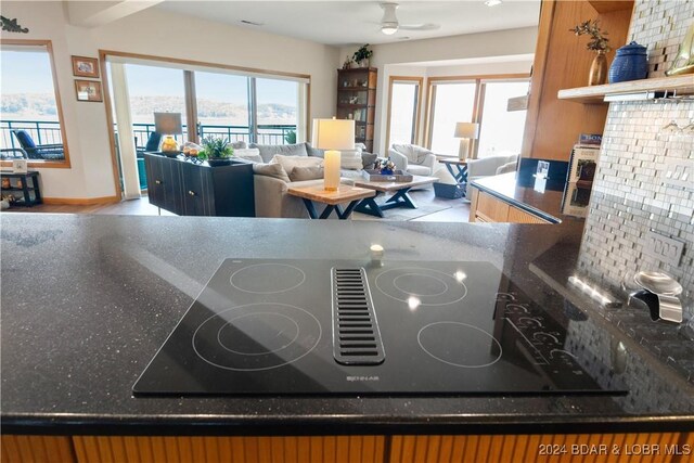 interior space featuring black electric stovetop, hardwood / wood-style floors, decorative backsplash, and ceiling fan