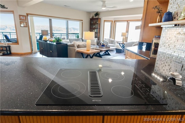 details featuring open shelves, tasteful backsplash, black electric cooktop, and a ceiling fan