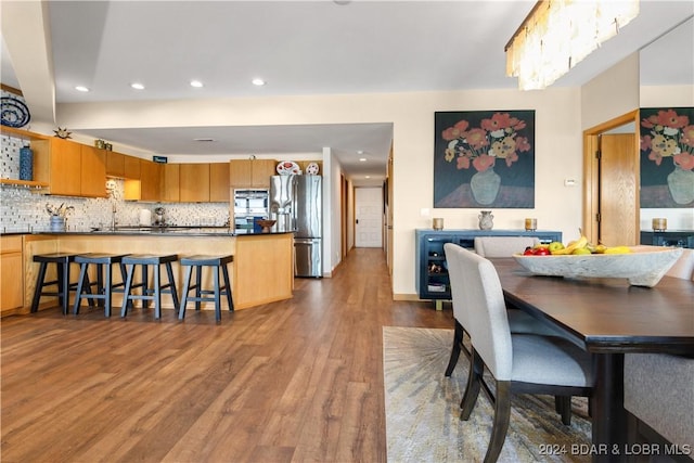 dining room with baseboards, wood finished floors, and recessed lighting