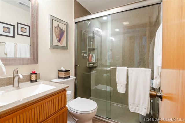 bathroom featuring a stall shower, visible vents, vanity, and toilet