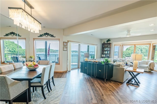 dining space featuring ceiling fan with notable chandelier and wood finished floors