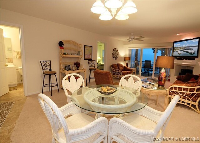 dining area featuring ceiling fan with notable chandelier