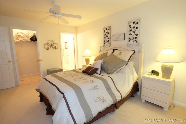 carpeted bedroom with a spacious closet, a closet, and ceiling fan