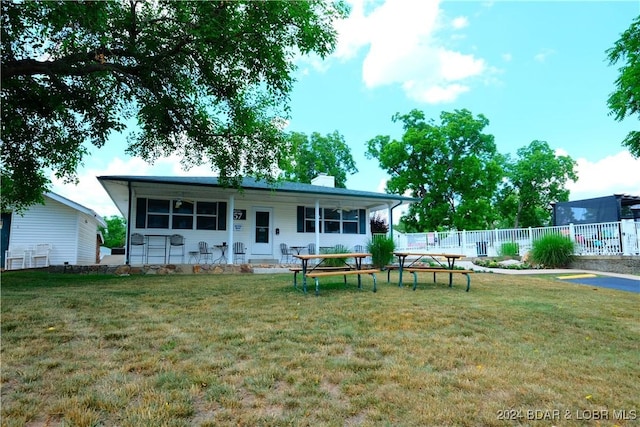 back of house featuring a yard, a chimney, and fence