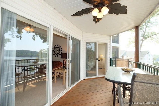 balcony with a water view and a ceiling fan