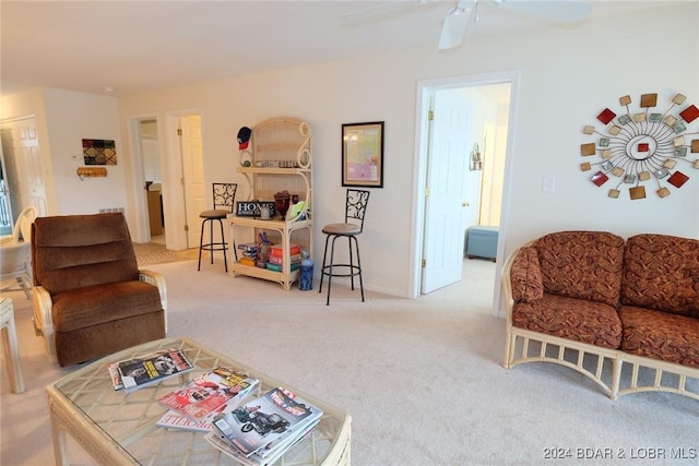 living area with a ceiling fan and light carpet