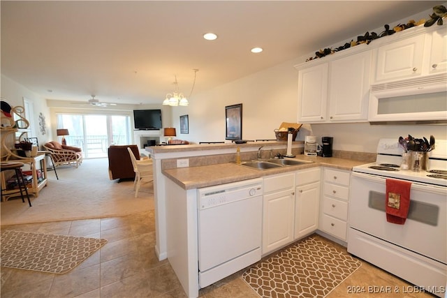 kitchen featuring open floor plan, light countertops, white appliances, and a sink