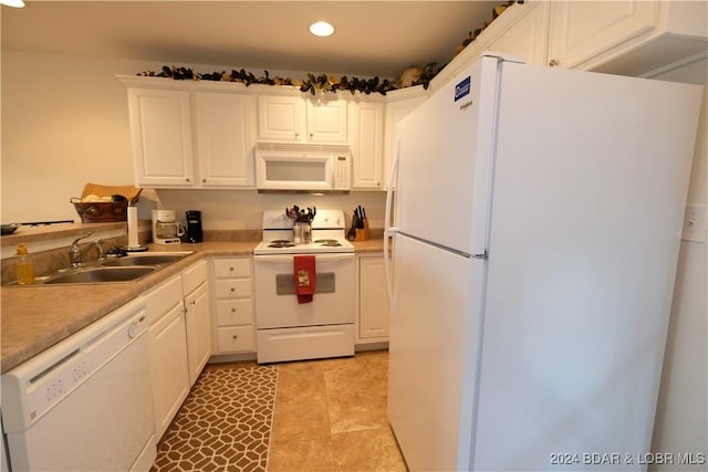 kitchen featuring white appliances, light countertops, white cabinetry, a sink, and recessed lighting