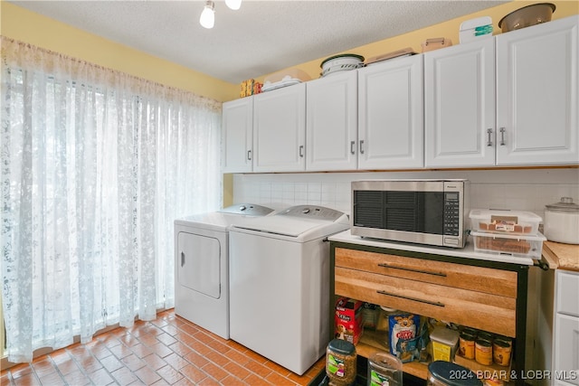 clothes washing area featuring a textured ceiling, separate washer and dryer, and cabinets