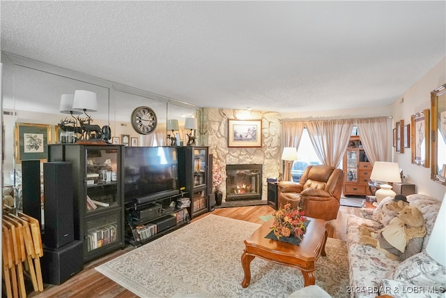 living room featuring hardwood / wood-style floors, a textured ceiling, and a fireplace