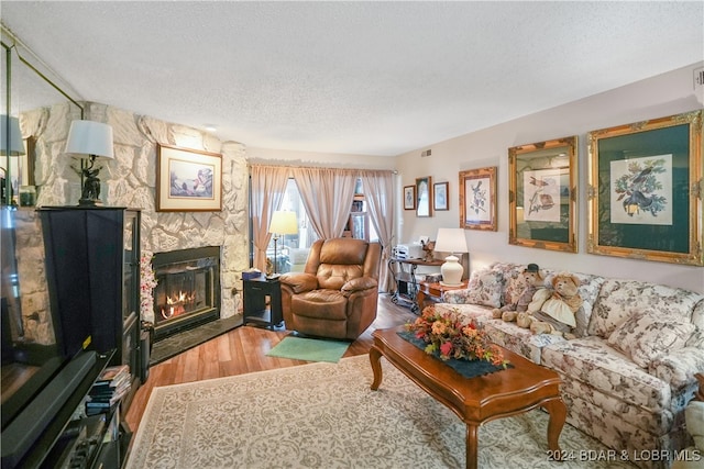 living room featuring hardwood / wood-style flooring, a textured ceiling, and a fireplace