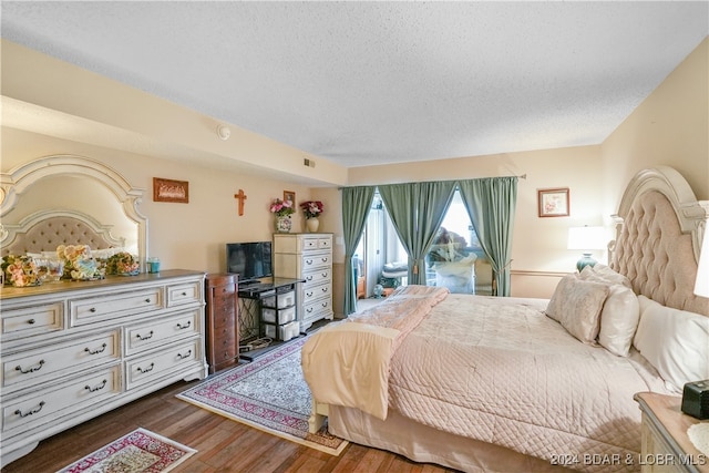 bedroom featuring dark wood-type flooring and a textured ceiling