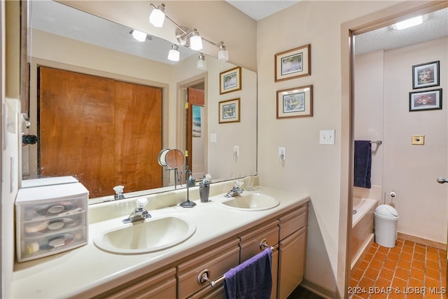 bathroom with a relaxing tiled tub, tile patterned floors, vanity, and a textured ceiling