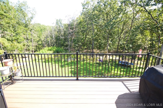 wooden deck with area for grilling and a yard