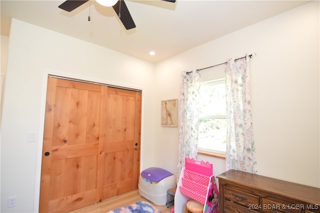 bedroom with ceiling fan, a closet, and wood-type flooring