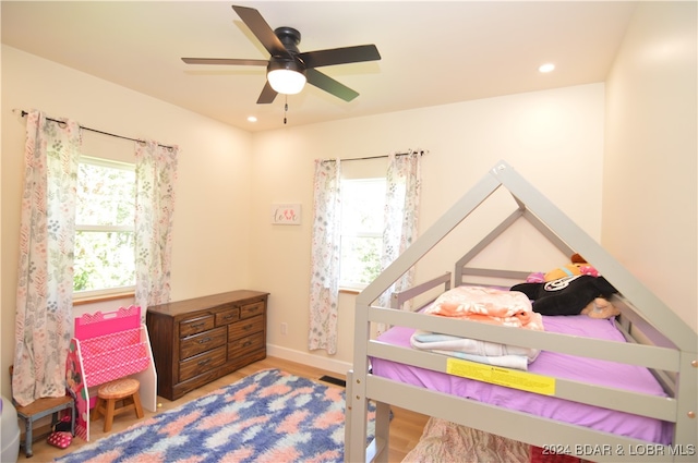 bedroom with hardwood / wood-style floors, multiple windows, and ceiling fan