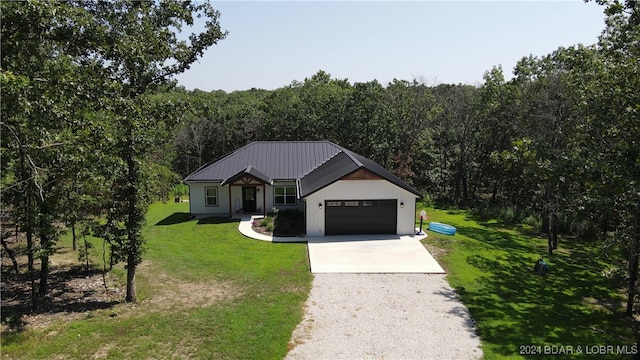 modern farmhouse featuring a front yard and a garage