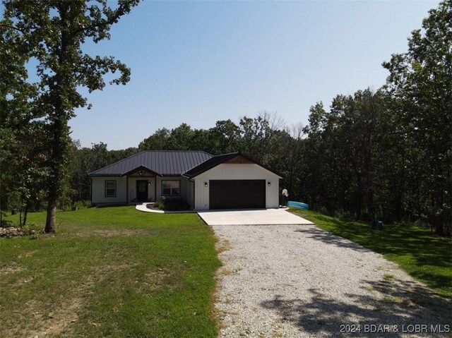 single story home featuring a garage and a front yard