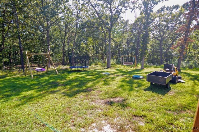 view of yard featuring a playground and a trampoline