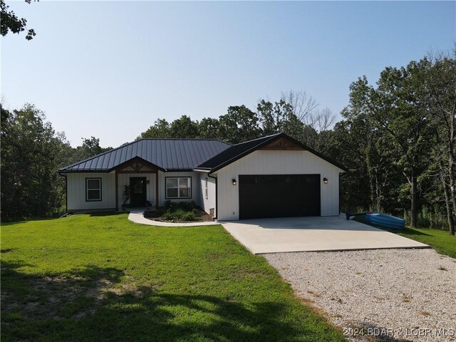 single story home featuring a garage and a front yard